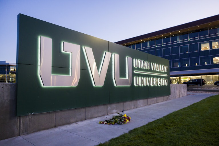 A bouquet of flowers lies on the ground in front of the sign for Utah Valley University, where Charlie Kirk was shot dead