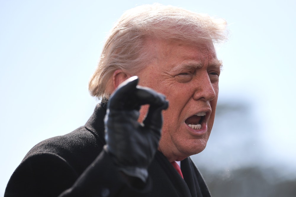 Donald Trump speaks vehemently while holding up right hand