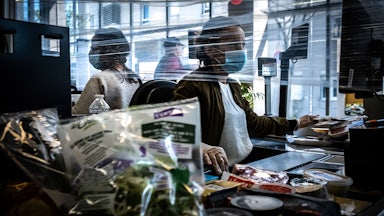 A cashier works wearing a face mask in a supermarket in Givors, near Lyon