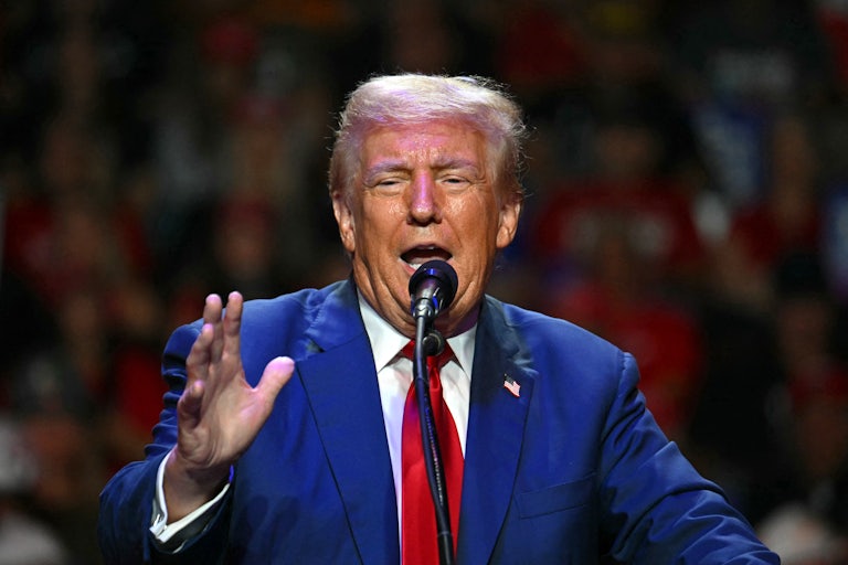Donald Trump speakinig animatedly and making hand gestures at a mic