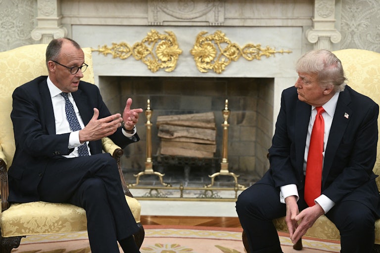 German Chancellor Friedrich Merz gestures and speaks while sitting next to Donald Trump in the Oval Office