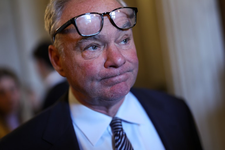 Tim Kaine rests his glasses on his forehead and makes a grim face