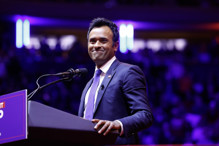 Vivek Ramaswamy smiles as he speaks behind a lectern.