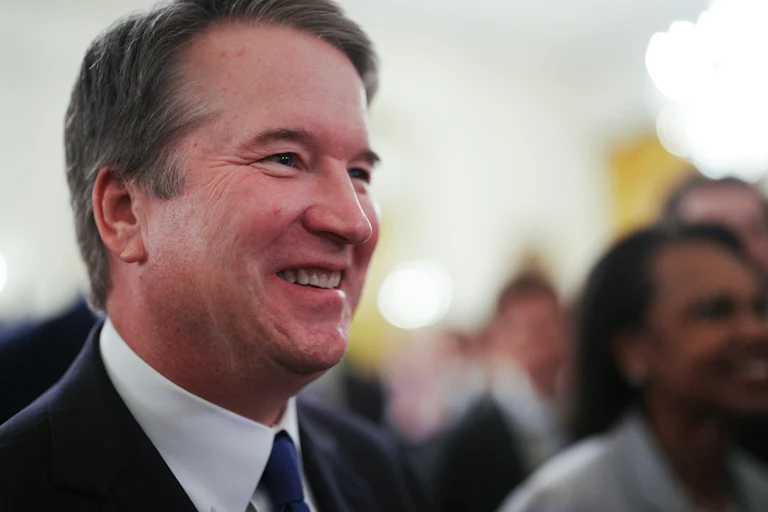 Supreme Court Justice Brett Kavanaugh smiles while walking out of the White House