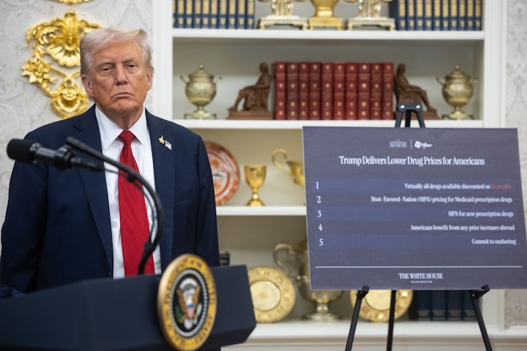 Donald Trump stands next to a sign that says, "Trump delivers lower drug prices for Americans"