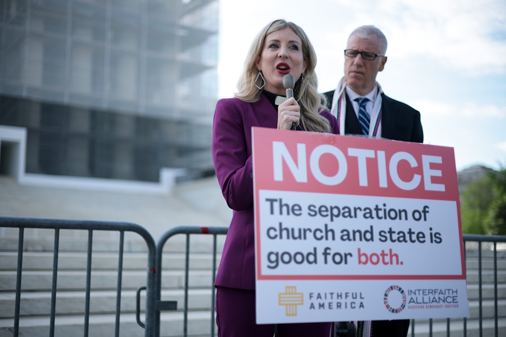 Rev. Shannon Fleck, executive director of Faithful America, speaks as Rev. Paul Brandeis Raushenbush, president and CEO of Interfaith Alliance, listens during a news conference outside the U.S. Supreme Court as it heard oral arguments in a case which could open up public funding for religious schools.