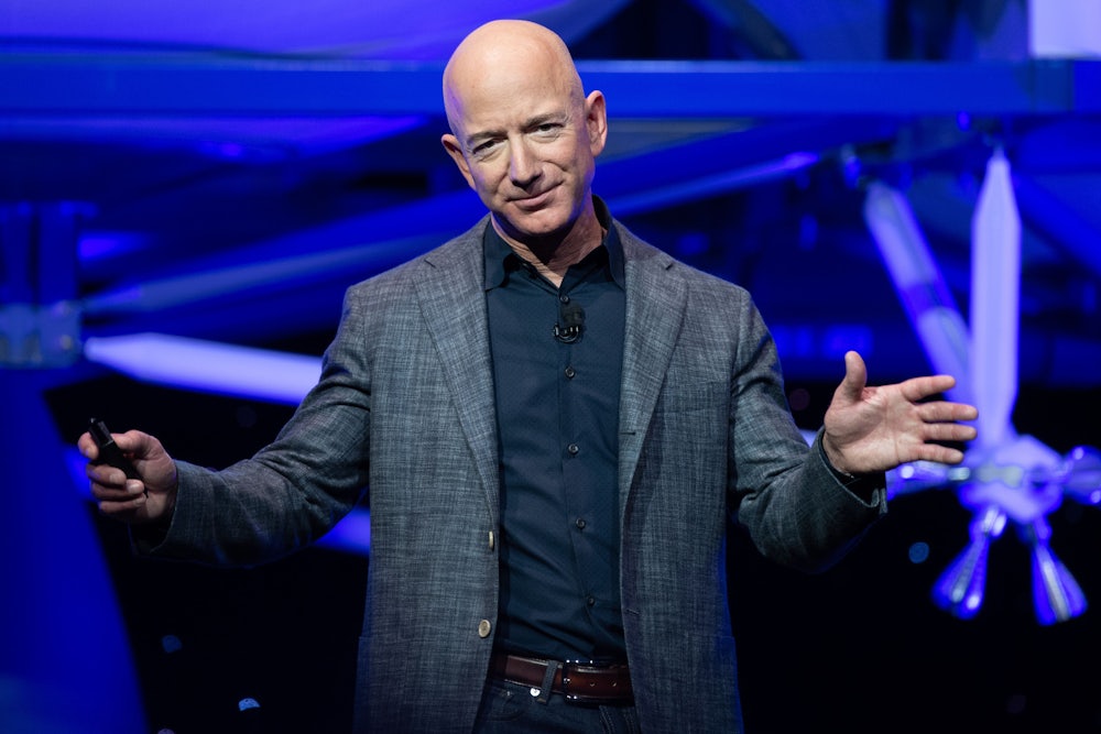 Jeff Bezos gestures with his arms during a Blue Origin presentation
