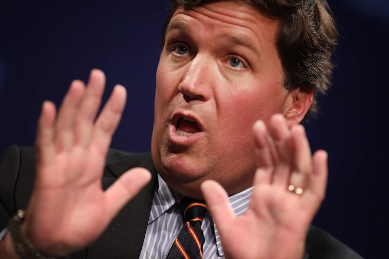 Tucker Carlson puts his hands up and makes a surprised face