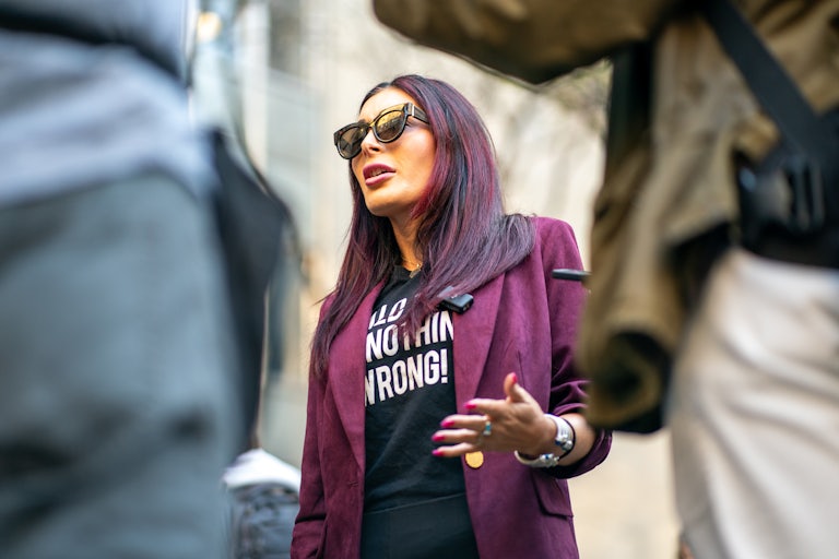 Laura Loomer gestures while speaking to reporters.