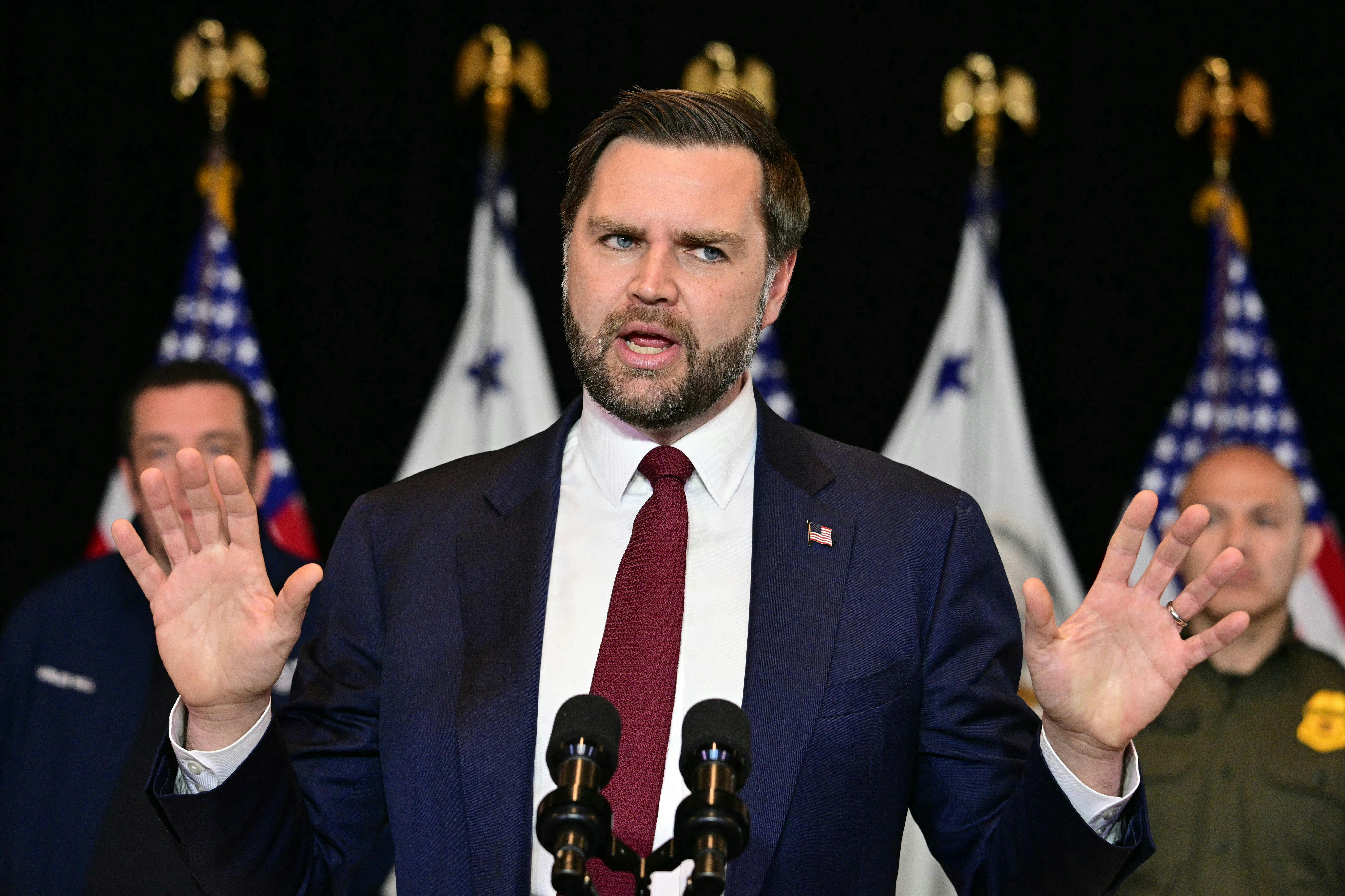 JD Vance holds up both hands while speaking