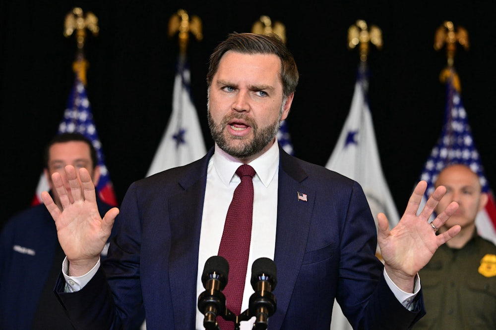 JD Vance holds up both hands while speaking