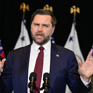 JD Vance holds up both hands while speaking