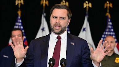 JD Vance holds up both hands while speaking