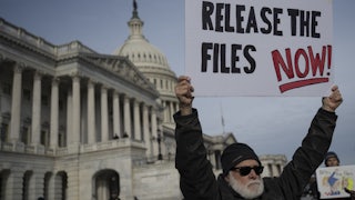 A person holds up a sign that says, “Release the files now!” while standing outside the U.S. Capitol