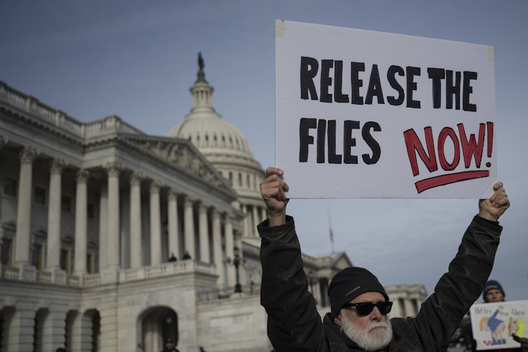 A person holds up a sign that says, “Release the files now!” while standing outside the U.S. Capitol