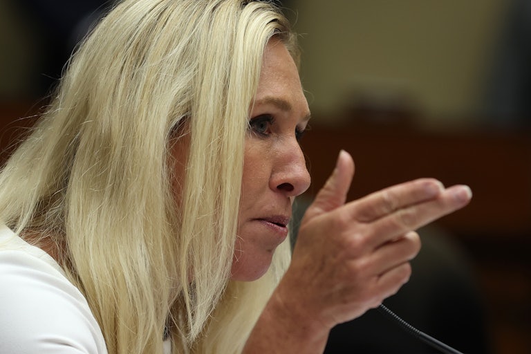 Marjorie Taylor Greene speaks and makes a gun with her right hand