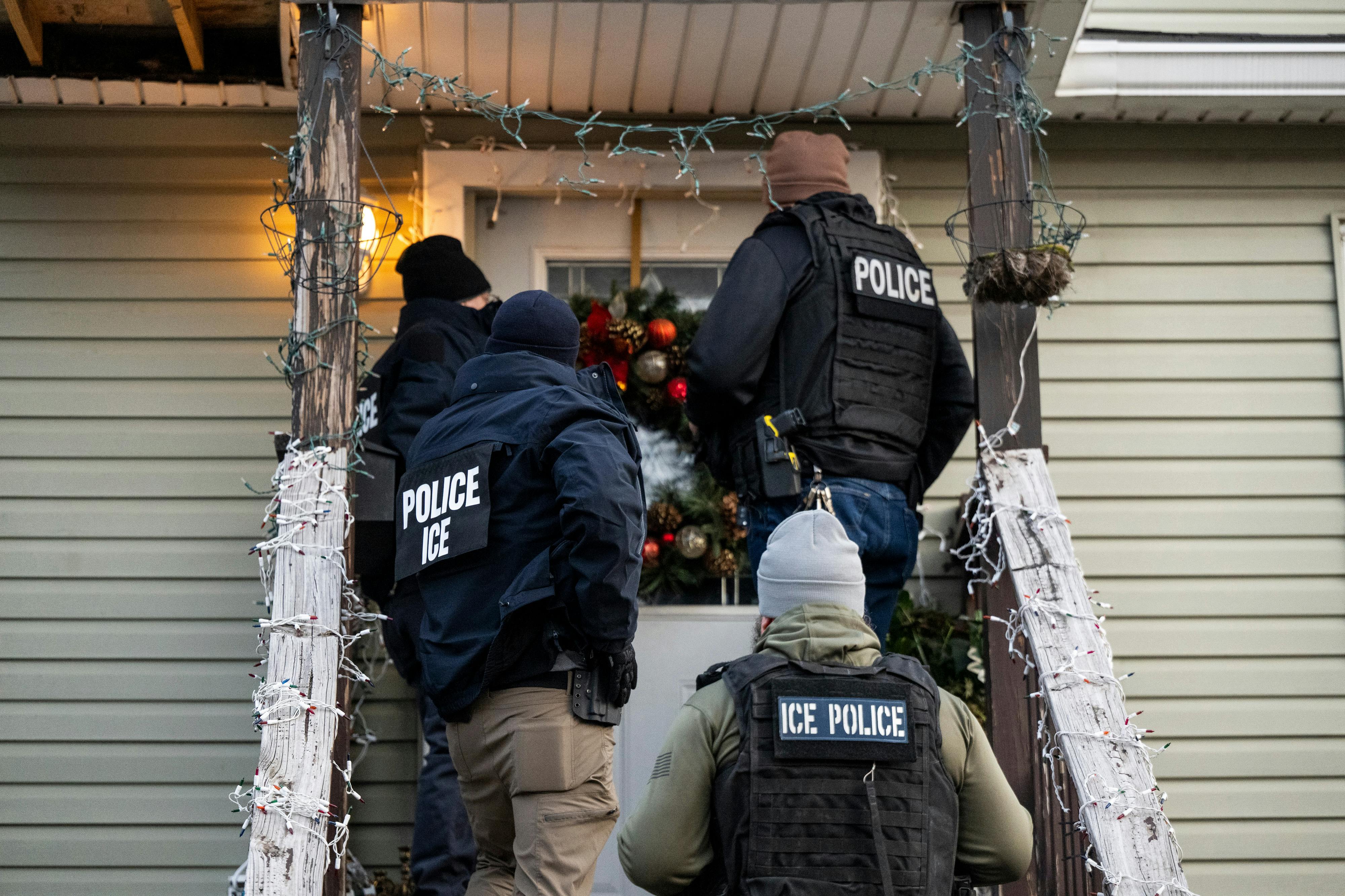 U.S. Immigration and Customs Enforcement (ICE) agents knock on the door of a residence during a multi-agency targeted enforcement operation in Chicago, Illinois, US, on Sunday, Jan. 26, 2025. 