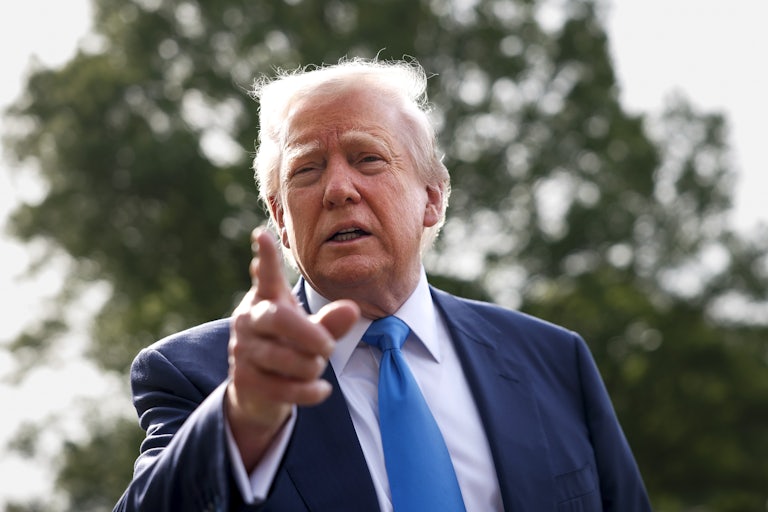 Donald Trump points at the camera while outside.