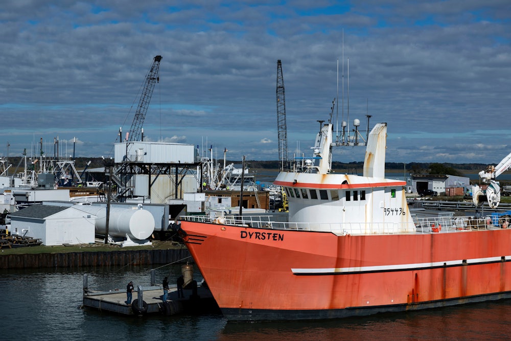 A red fishing boat is seen at a dock.