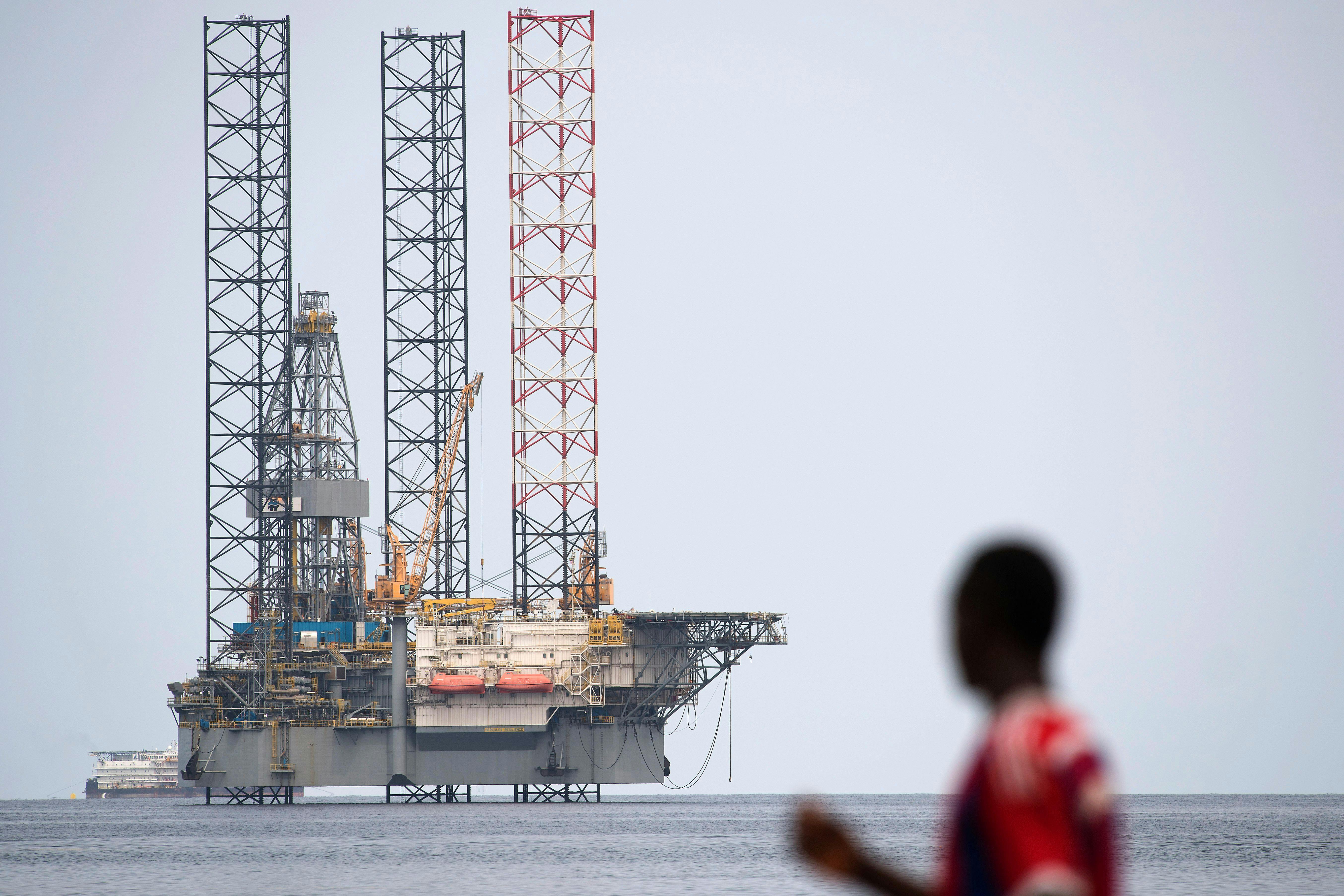 A person looks at an off-shore oil rig.
