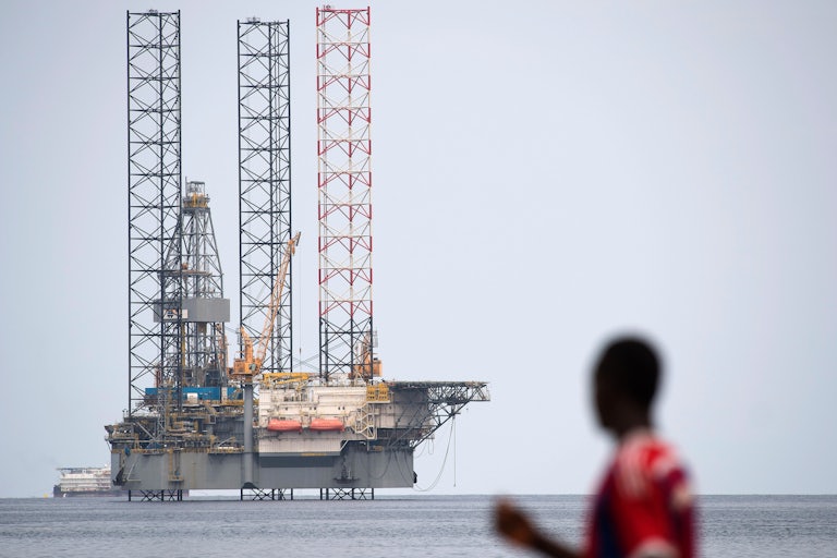 A person looks at an off-shore oil rig.