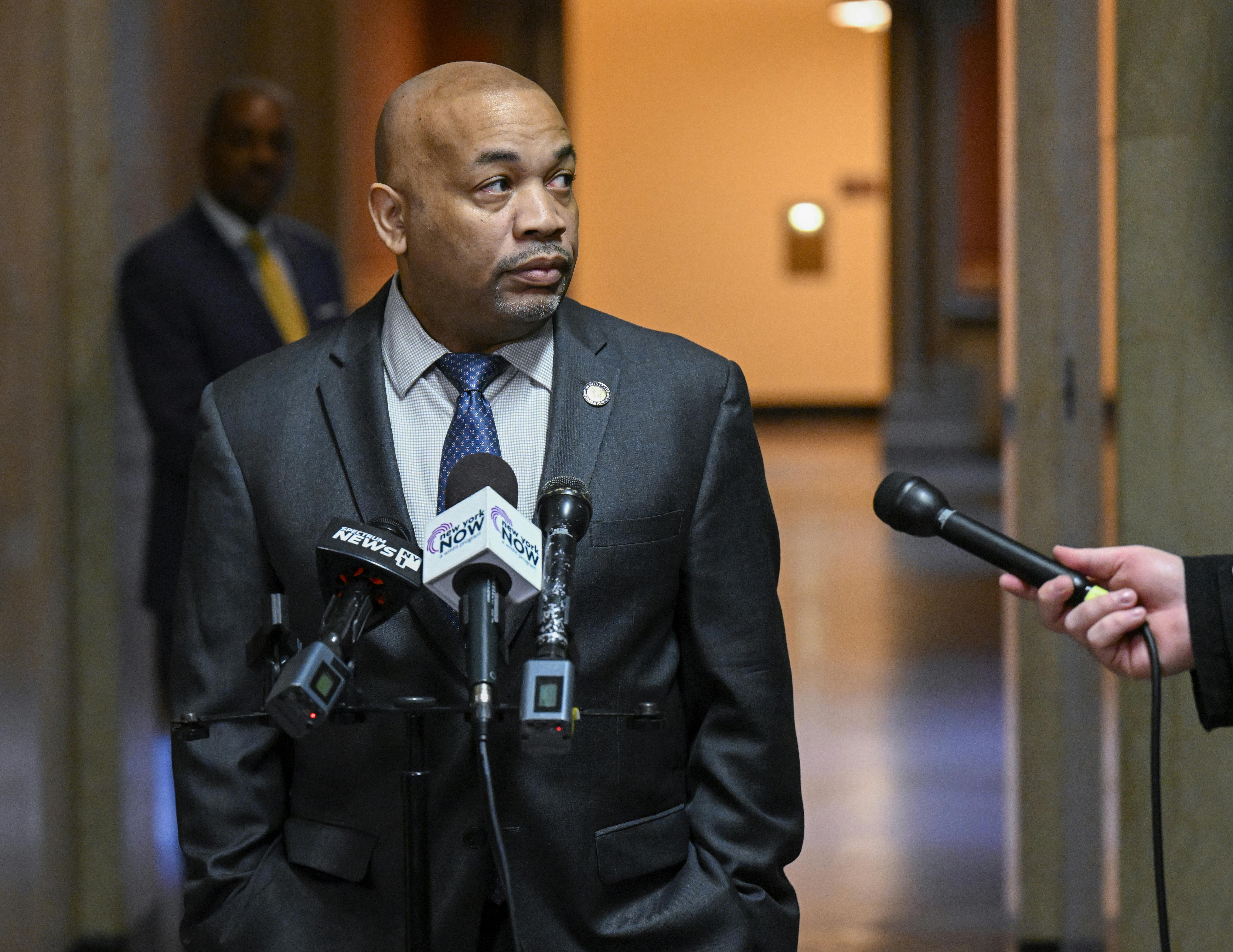 Carl Heastie speaks into microphones at a podium.