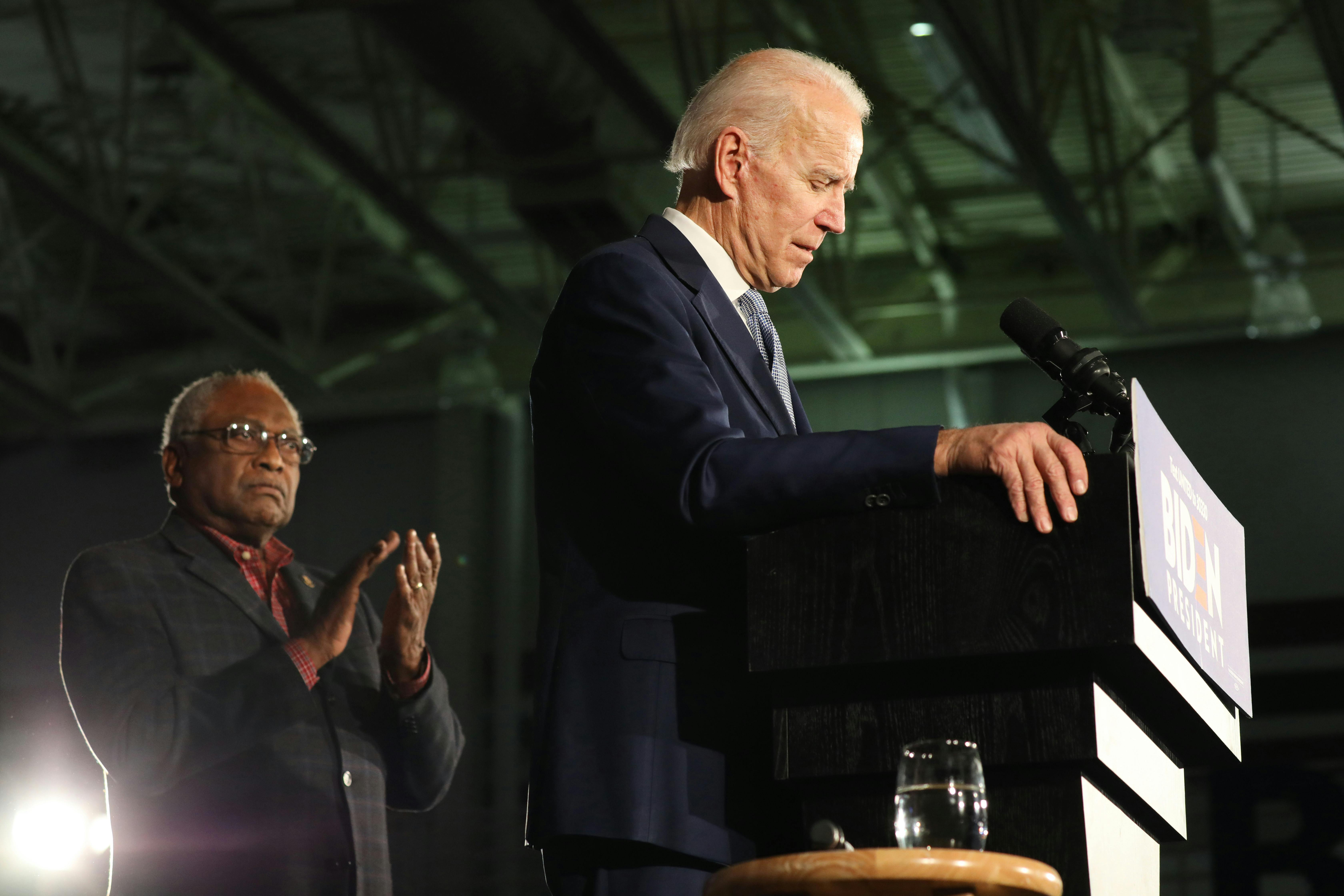 South Carolina Congressman Jim Clyburn stands behind Joe Biden, applauding.