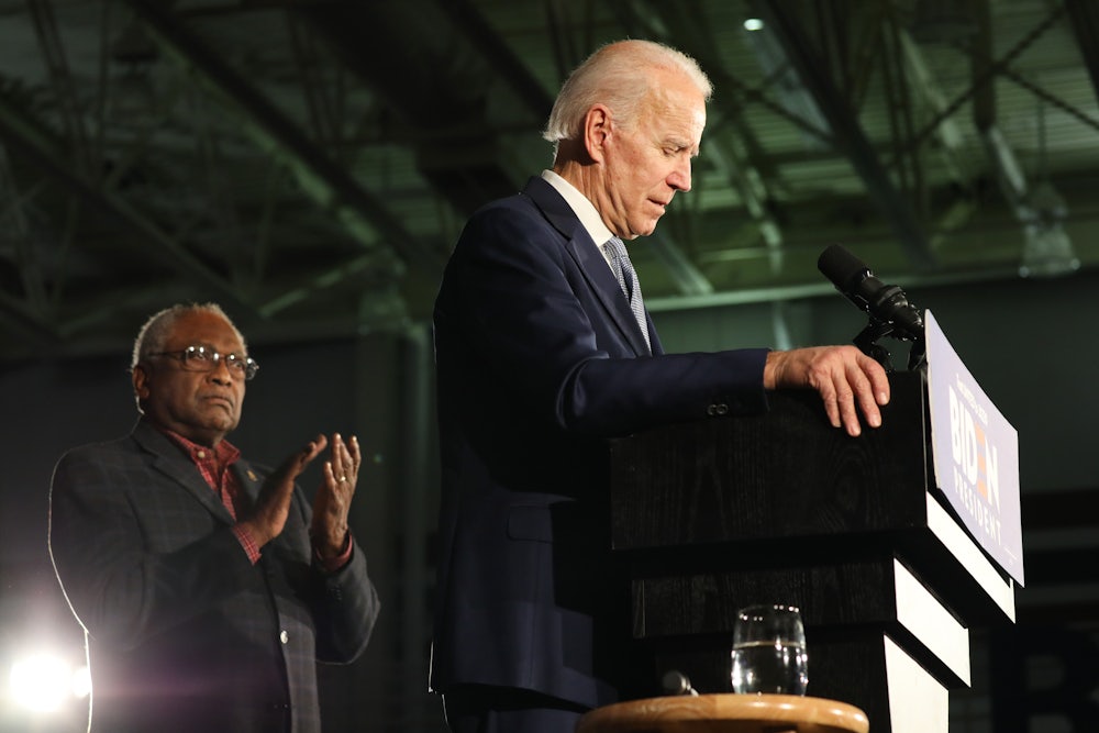South Carolina Congressman Jim Clyburn stands behind Joe Biden, applauding.