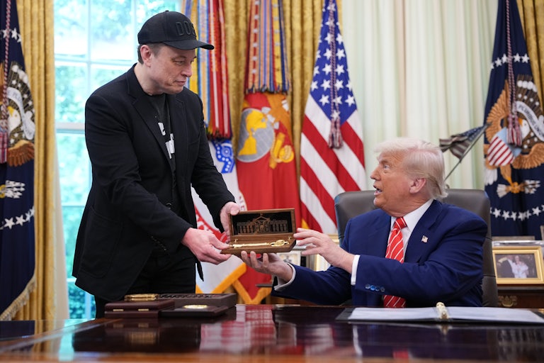 Donald Trump, seated behind his desk in the Oval Office, hands Elon Musk (standing above him) a golden key.