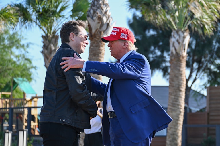 Donald Trump pats Elon Musk on the arm as the two embrace