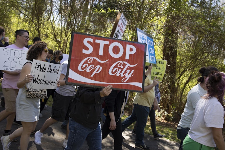 A protester holds a sign that reads "Stop Cop City."