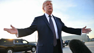 President Donald Trump speaks to reporters on the tarmac and splays his arms outward