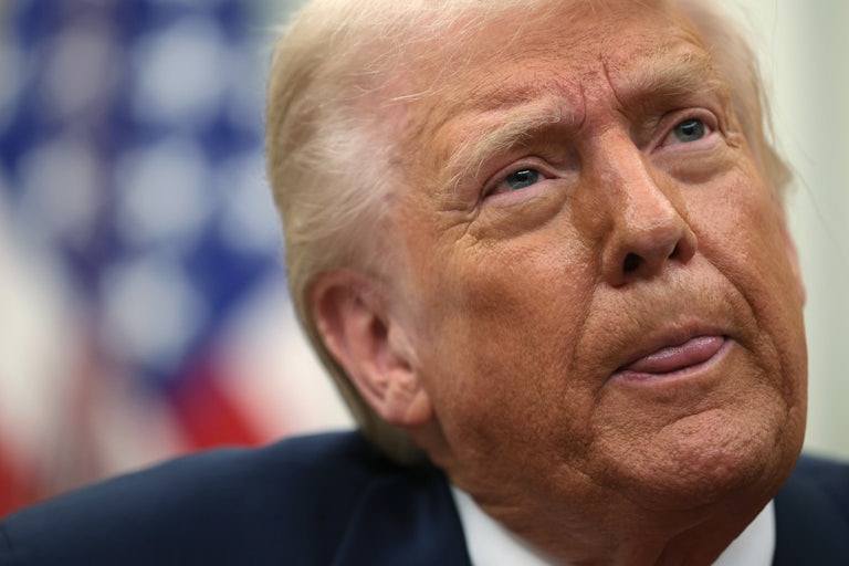 Donald Trump’s tongue sticks out a little as he speaks to reporters in the Oval Office