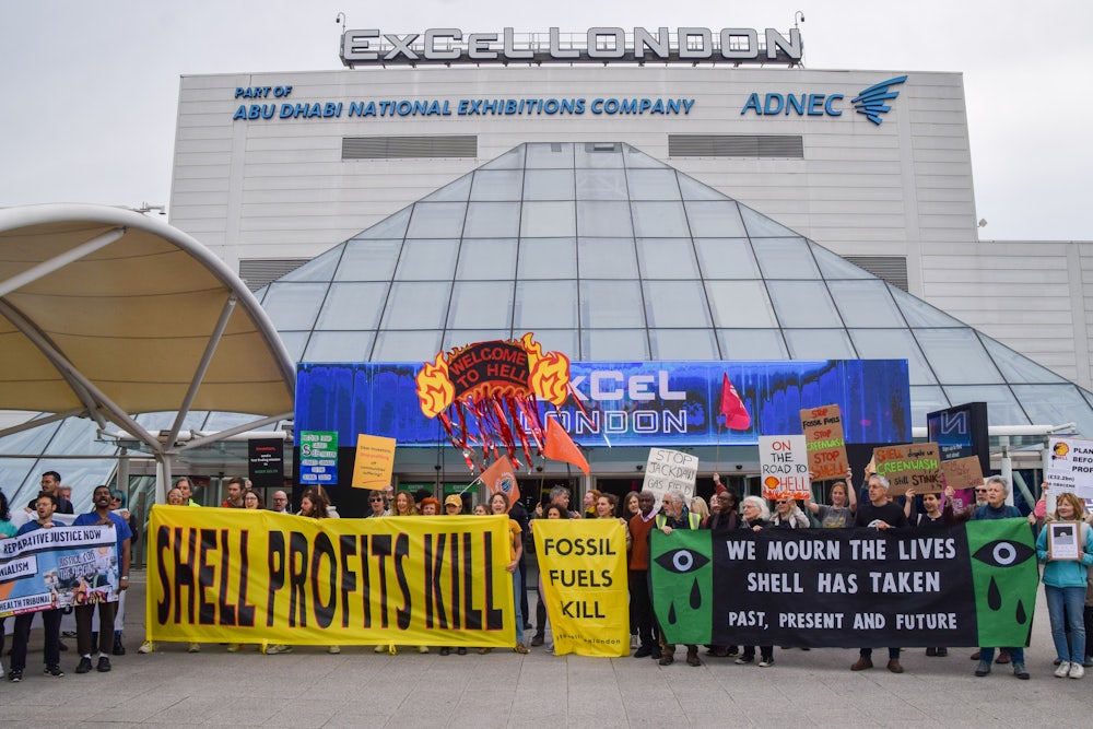 Protesters hold signs reading "Shell Profits Kill" and "We Mourn the Lives Shell Has Taken."