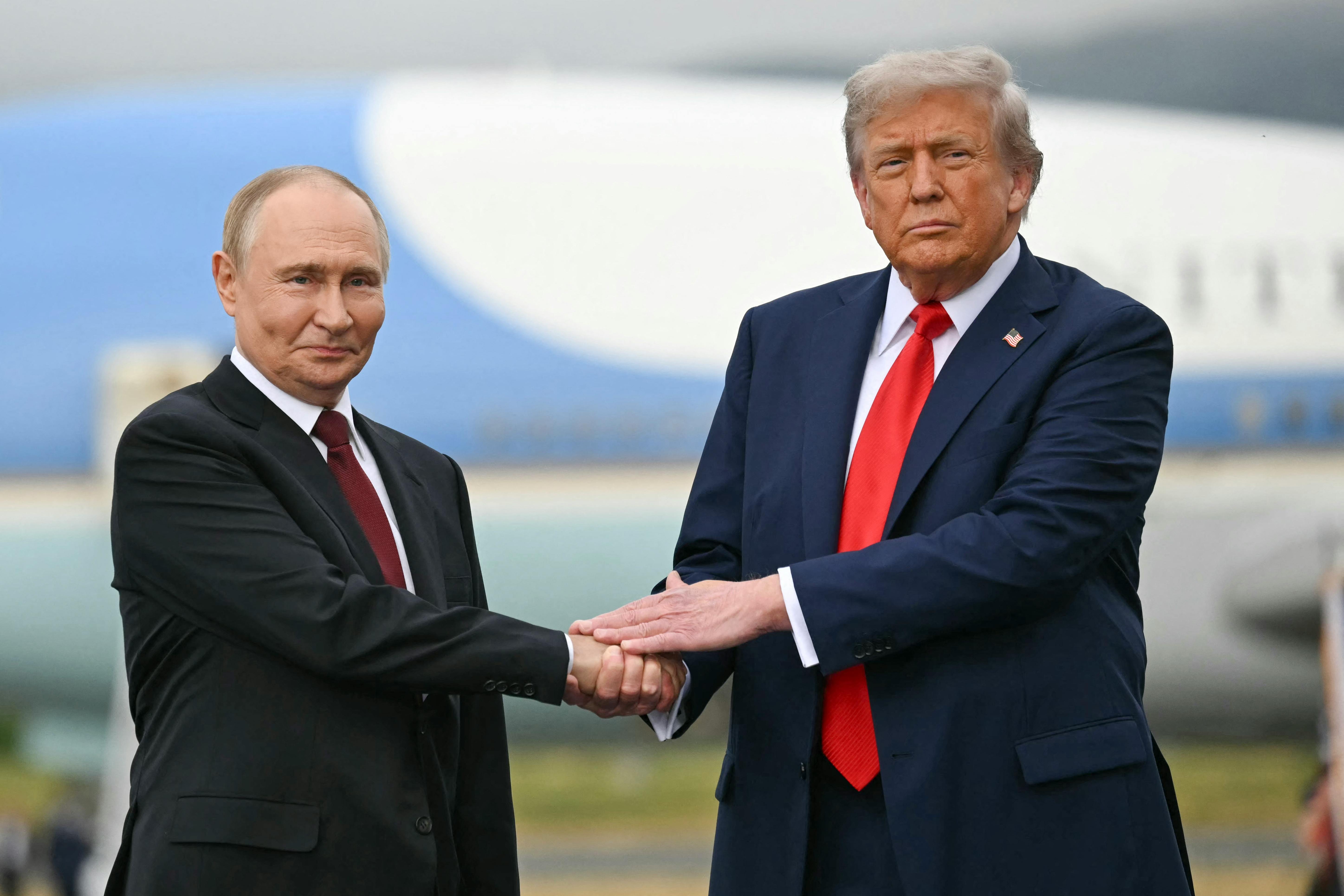 Russian President Vladimir Putin and Donald Trump shake hands