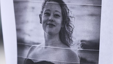 Paper with black and white photo of Renee Good