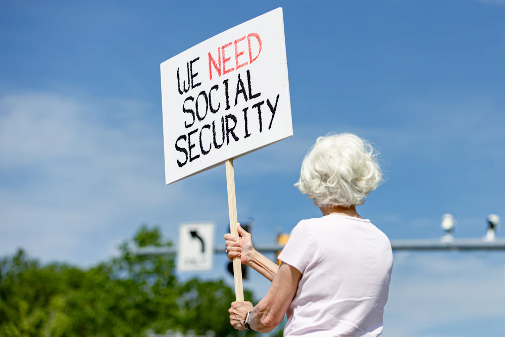 Lynn McKerral holds a sign in support of Social Security Administration workers in front of the agency’s headquarters.