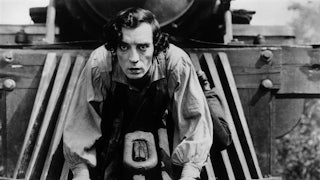 Buster Keaton clings to the front of a train in a black-and-white still
