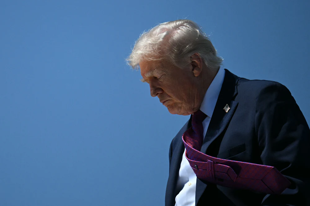 Donald Trump looks down as he exits Air Force One