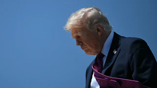 Donald Trump looks down as he exits Air Force One