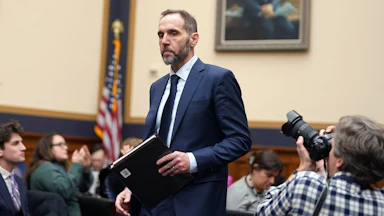 Jack Smith holds a folder while in a congressional hearing