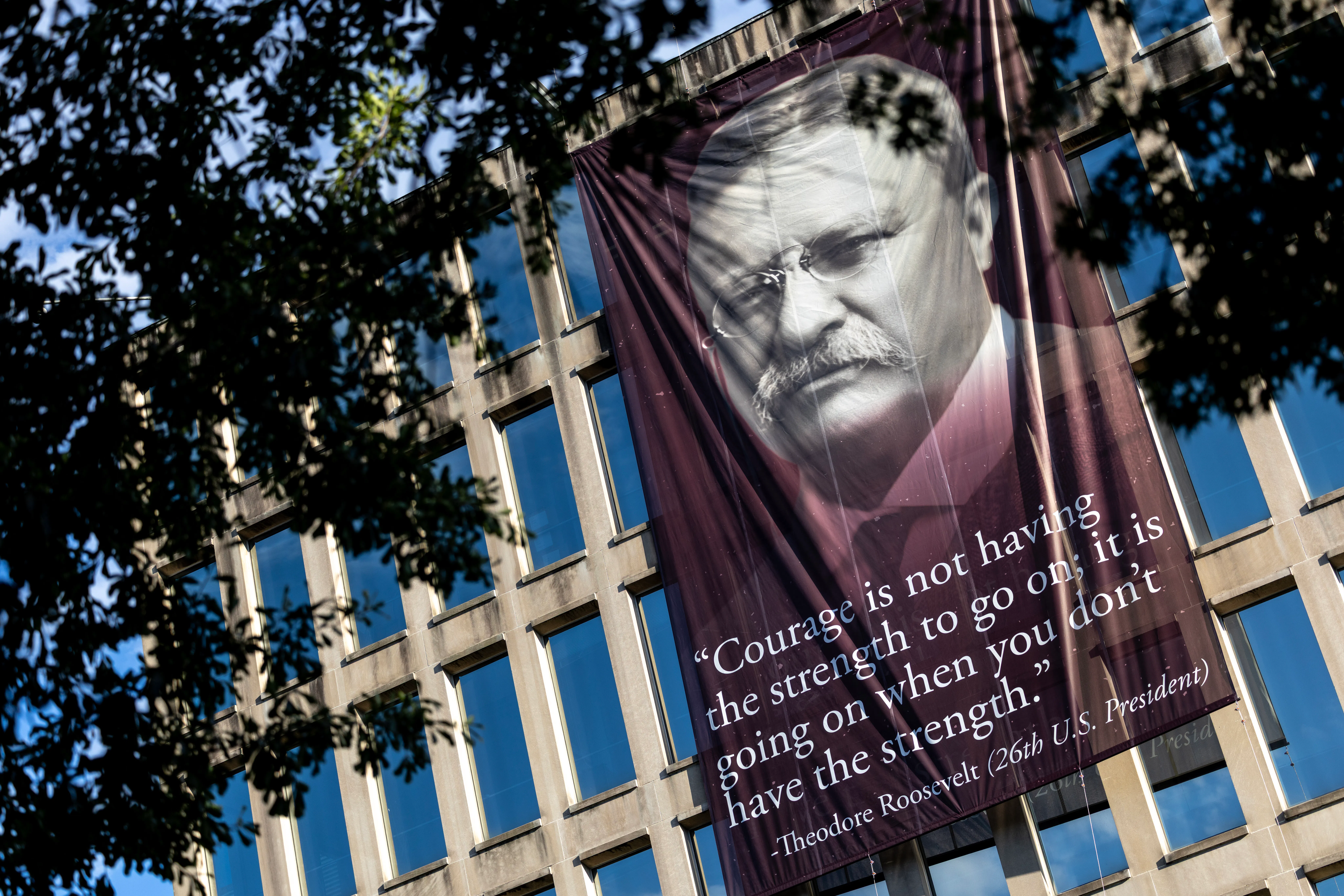 A banner that reads, “Courage is not having the strength to go on; it is going on when you don’t have the strength,” with a photo of the 26th U.S. president Theodore Roosevelt, is hung outside the Theodore Roosevelt Federal Building in Washington, D.C. The quote’s origin can be traced back to multiple different people but attributed to President Roosevelt on the banner. 