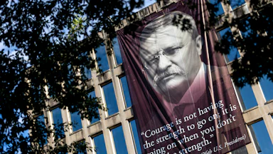 A banner that reads, “Courage is not having the strength to go on; it is going on when you don’t have the strength,” with a photo of the 26th U.S. president Theodore Roosevelt, is hung outside the Theodore Roosevelt Federal Building in Washington, D.C. The quote’s origin can be traced back to multiple different people but attributed to President Roosevelt on the banner.