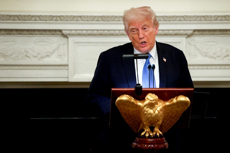 Donald Trump speaks at the Kennedy Center while standing behind a lectern with a gold eagle.