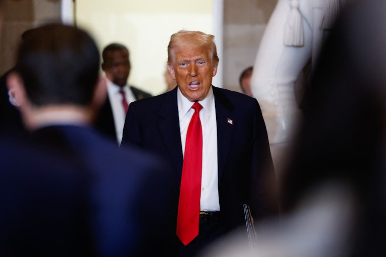 Donald Trump speaks to reporters while walking in the U.S. Capitol