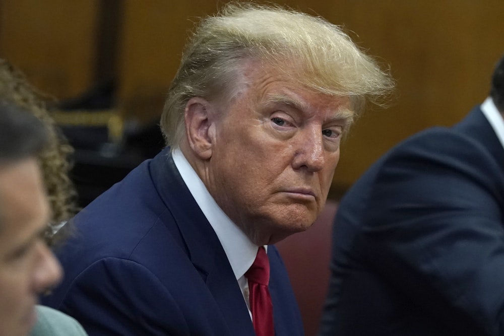 Donald Trump looks to his right while seated.
