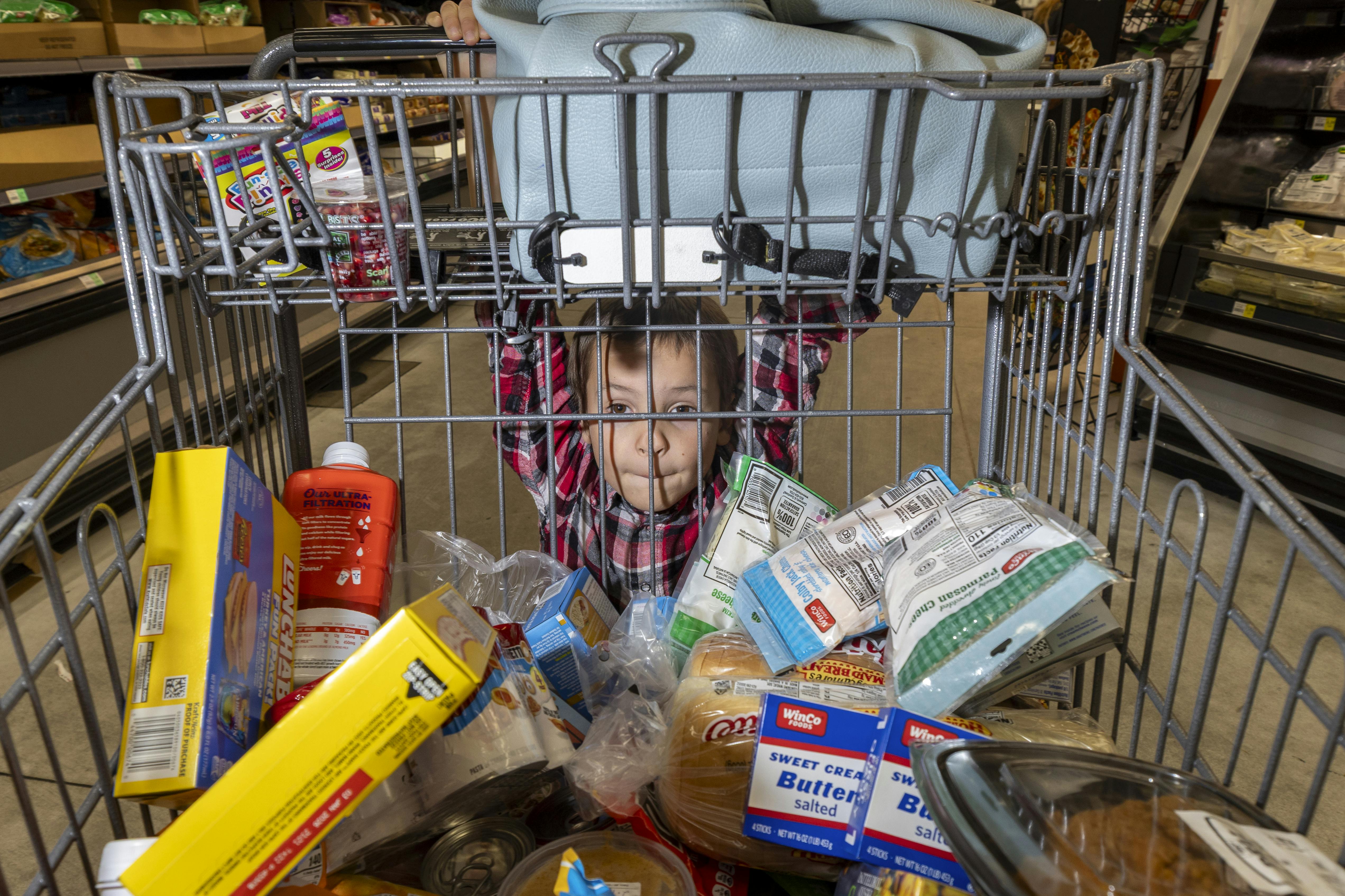 Royce Rasmussen, 8, mans a grocery cart at the store with his mother as they shop with limited Supplemental Nutrition Assistance Program (SNAP) benefits in Idaho Falls, Idaho. More than 130,000 Idahoans receive SNAP benefits.