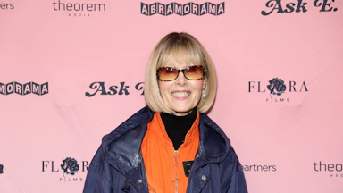E. Jean Carroll smiling in front of a backdrop