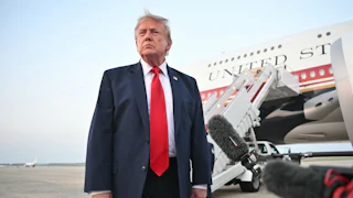 Donald Trump stands in front of reporters next to Air Force One