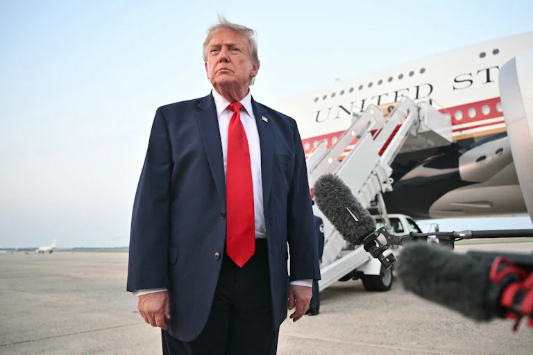 Donald Trump stands in front of reporters next to Air Force One